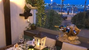 An outdoor dining area with a view of the marina at dusk. - Villa Rio Guest House Suites (Portimão)