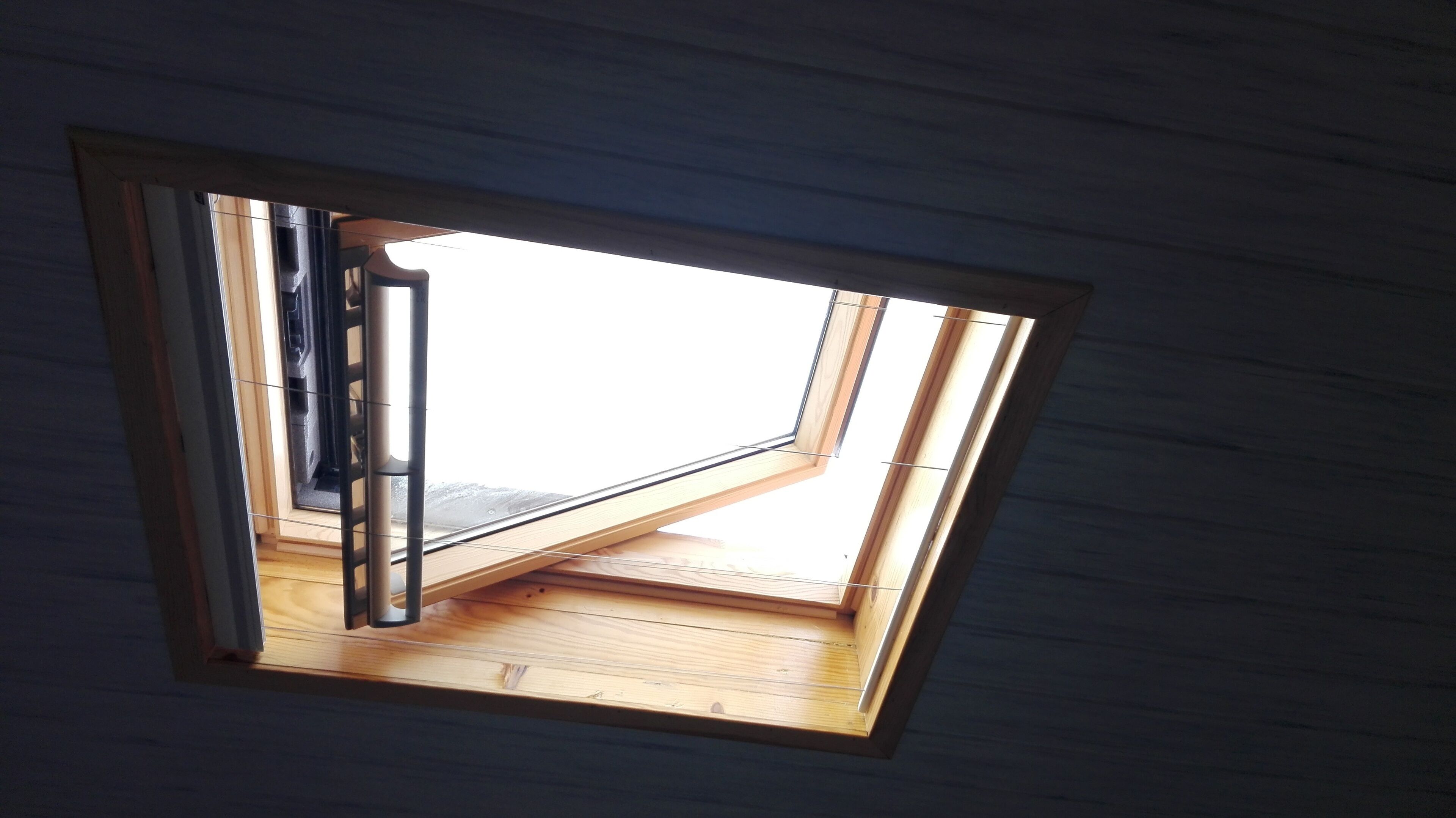 A skylight window with a wooden floor and a metal frame.