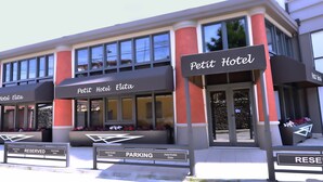 Un hotel con señalización que indica 'Petit Hotel Elita' y estacionamiento 'RESERVADO'.