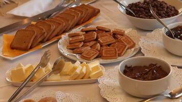 Een buffet met diverse etenswaren, zoals brood, kaas en koekjes.
