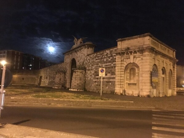 A historic stone building with arched windows and a central dome, located at a street corner with a no parking sign. - Da Linda (Livorno)