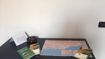 A desk with a map, books, a bowl of snacks, and a sign.