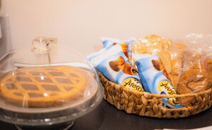 Una exhibición de alimentos que incluye pastel, pan y bocadillos envasados.