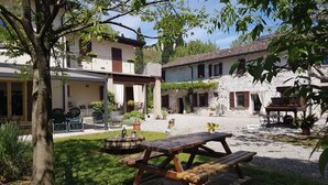 A courtyard with a picnic table, surrounded by stone buildings with balconies and potted plants. - L'Isolo Bed and Breakfast (Monzambano)