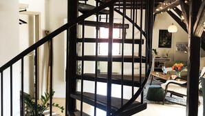Una escalera de caracol con barandilla de metal negro que conduce a un piso superior.
