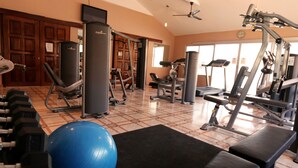 A gym with various exercise equipment, including dumbbells, a blue exercise ball, and weight machines. - Luxury Poolside Apartment. Your Serene Getaway Awaits! (El Pajonal)