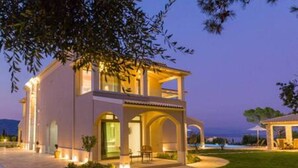 A two-story building with a covered patio, a swimming pool, and a view of the sea. - Villa Onore - Luxurious pool jacuzzi (Dassia)