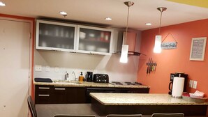Una cocina compacta con una isla central, un comedor con cuatro sillas y un soporte de cuchillos en la pared.
