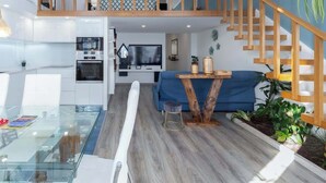 Un appartement moderne doté d’un espace de vie de style « loft », d’une cuisine et d’un coin repas.