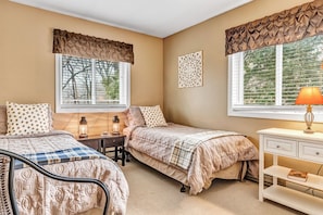 A bedroom with two beds, a desk, a lamp, and a dresser. - Condo above Quechee Village with Golf Views, Windsor (Hartford)