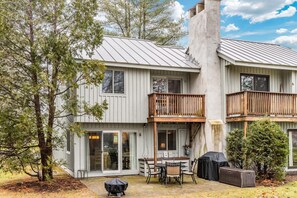 A two-story building with a balcony, a covered patio, and a grill area. - Condo above Quechee Village with Golf Views, Windsor (Hartford)