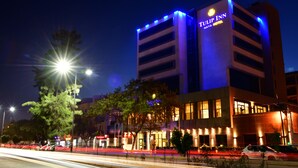 A modern hotel with a prominent sign, multiple floors, and illuminated windows. - Naya (Algiers)