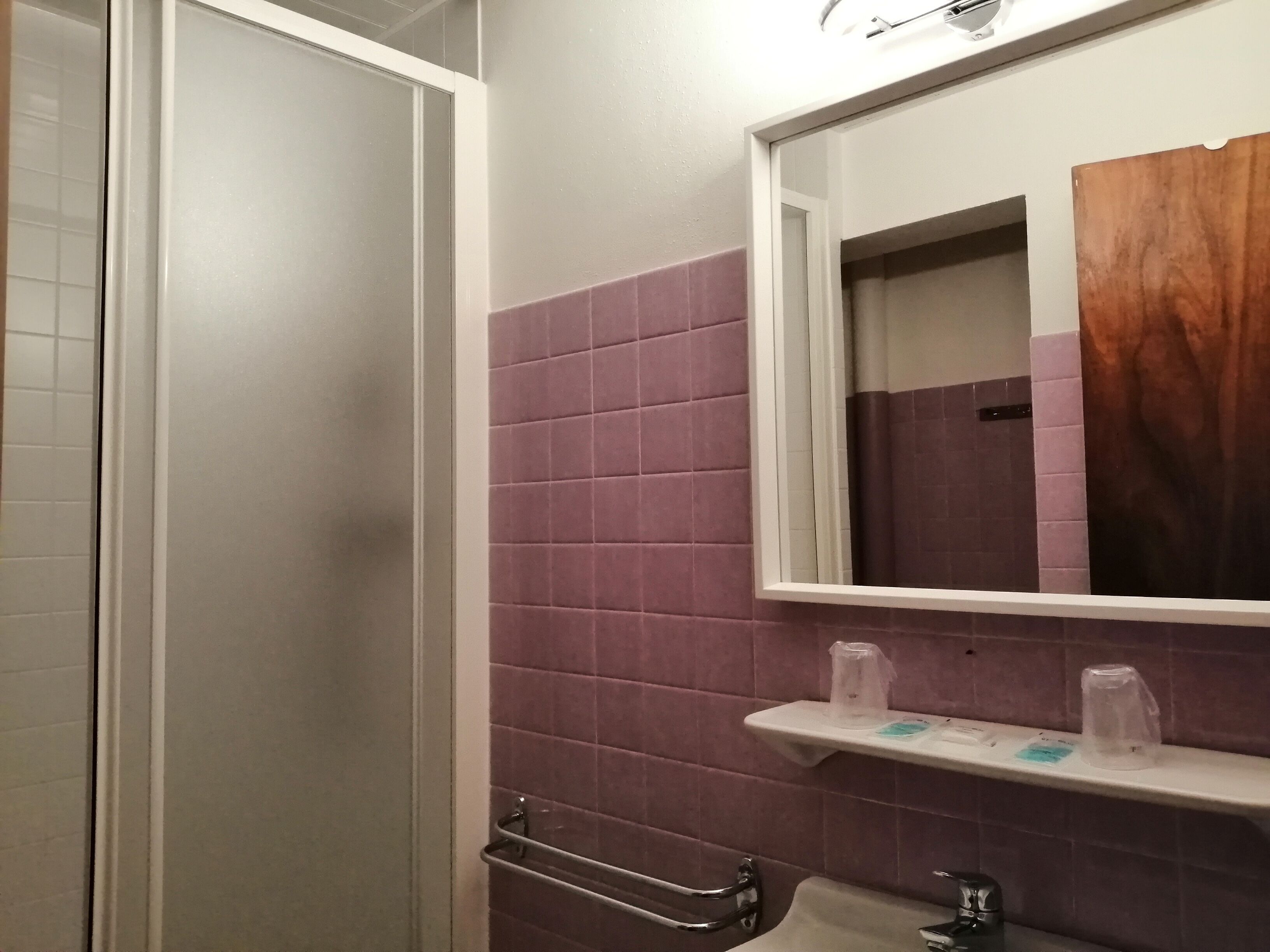 A bathroom with a shower, a sink, and a mirror.