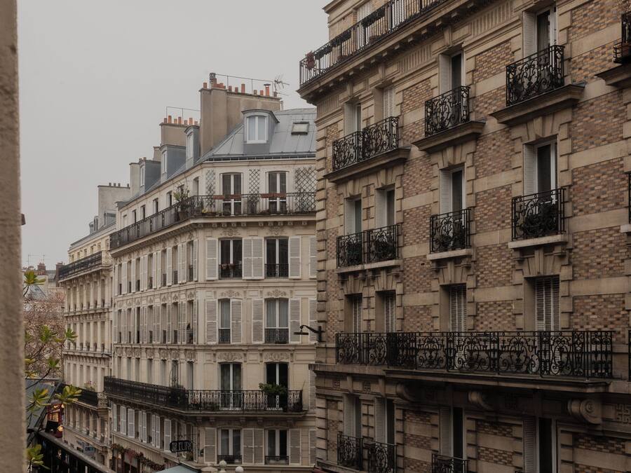 Una hilera de edificios históricos con balcones ornamentados y un estilo arquitectónico tradicional europeo.