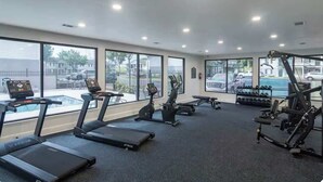 A gym with treadmills, elliptical machines, and weight equipment.