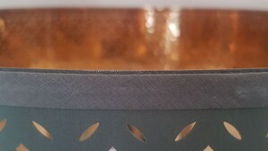 A close-up of a metallic edge with a textured surface and a patterned fabric underneath. - Silver Lining - Luxury Jackson Apartment (Edinburgh)