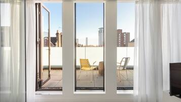 A room with large windows, a sliding door, and a view of the cityscape.