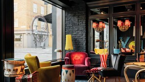 A cozy interior with a red armchair, yellow armchair, and a drum set.