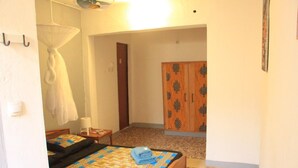 A hotel room with two beds, a wardrobe, a small table, and a mosquito net. - Ouaka Hotel (Ouagadougou)