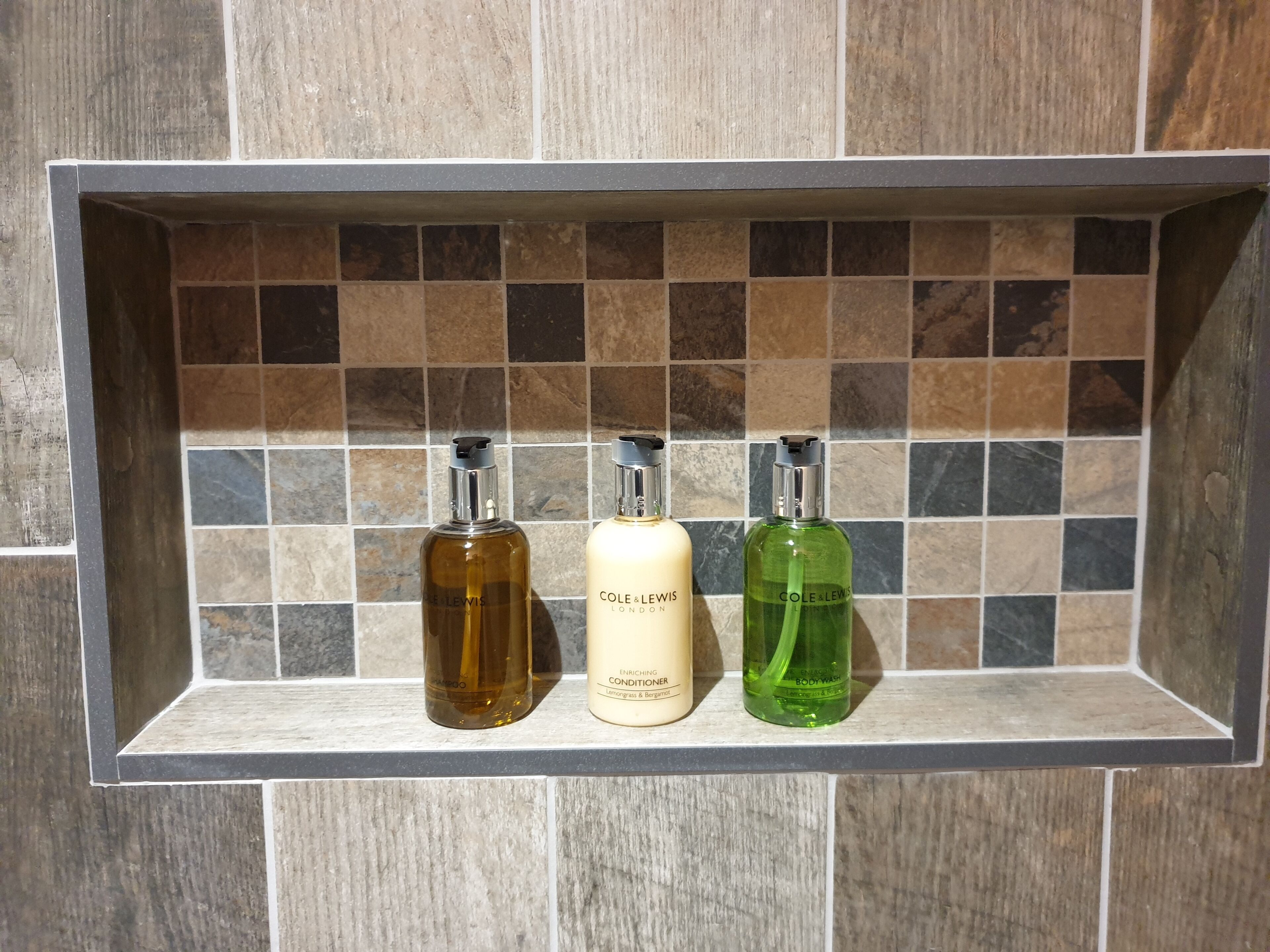 A shelf with three bottles of personal care products.