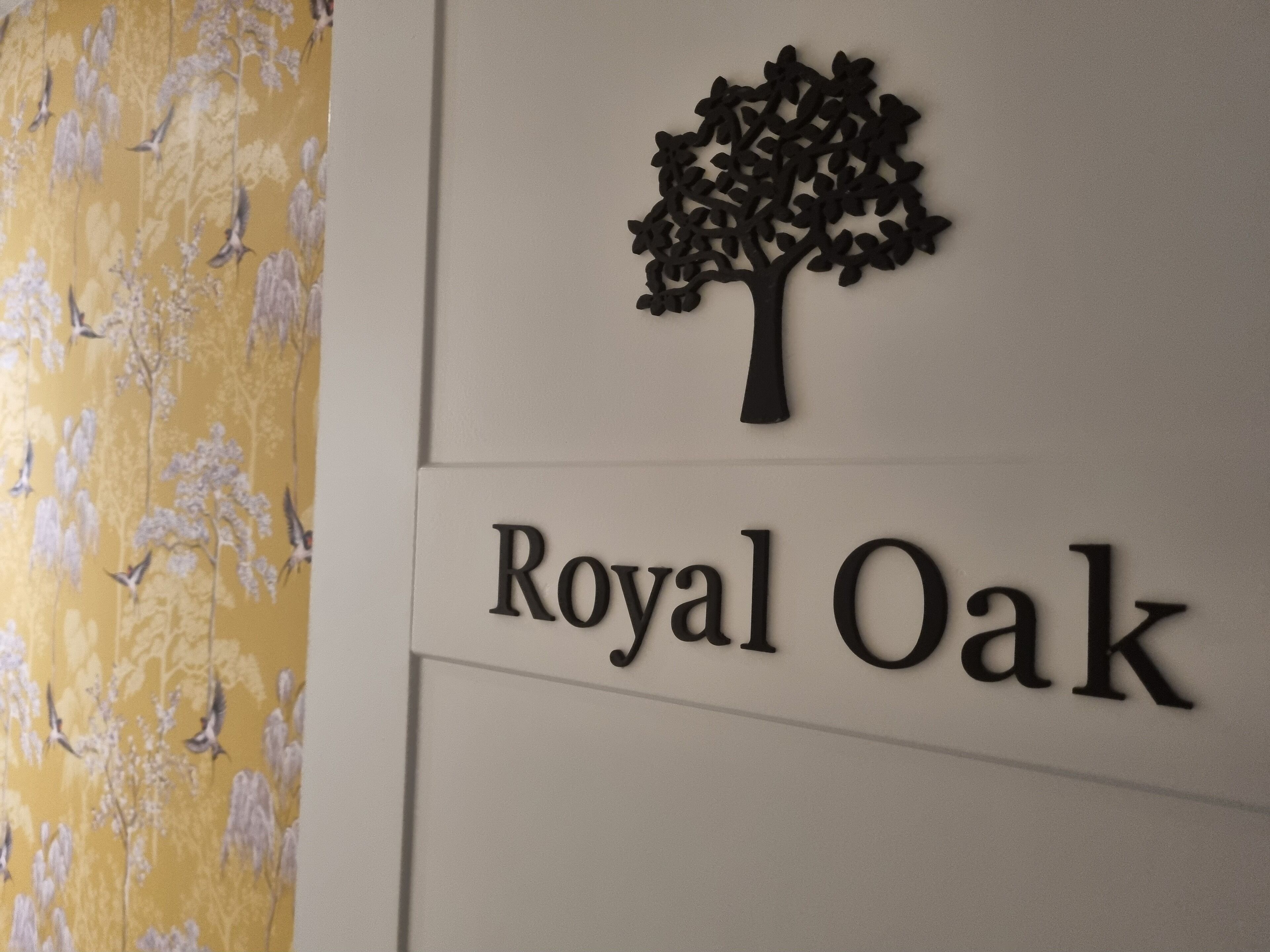 A wall with a tree silhouette and the text "Royal Oak" below it.