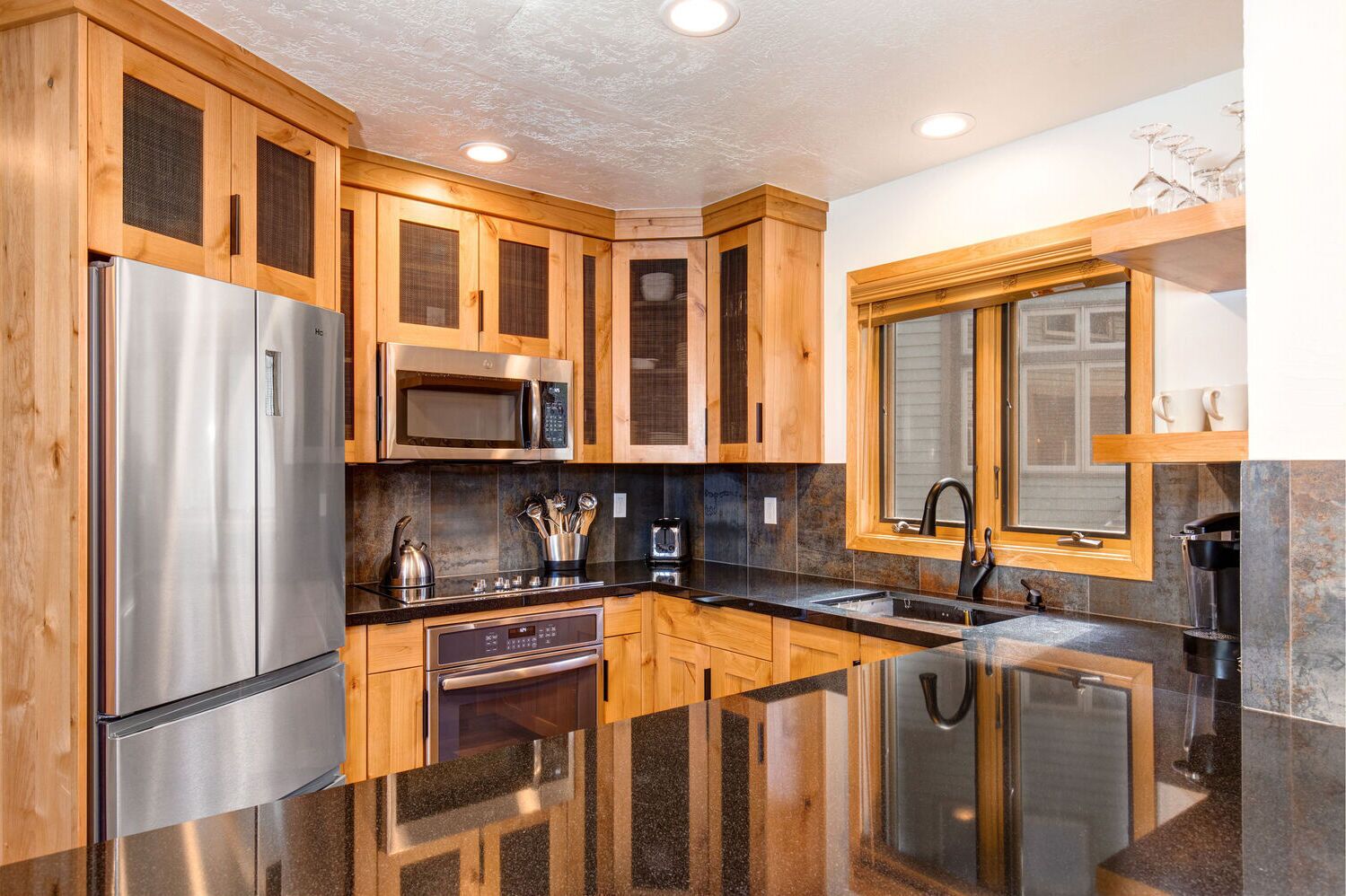 A modern kitchen with wooden cabinets, stainless steel appliances, and a large island with a sink.