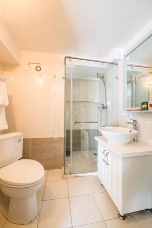 A modern bathroom with a glass-enclosed shower, a white sink, and a toilet. - Tianjin Yujingxuan Boutique Apartments (Tianjin)
