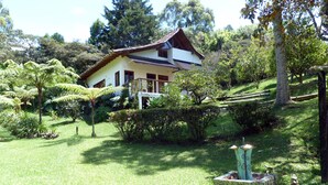 A house with a garden, surrounded by trees and ferns. - Casa Jade (Rionegro)