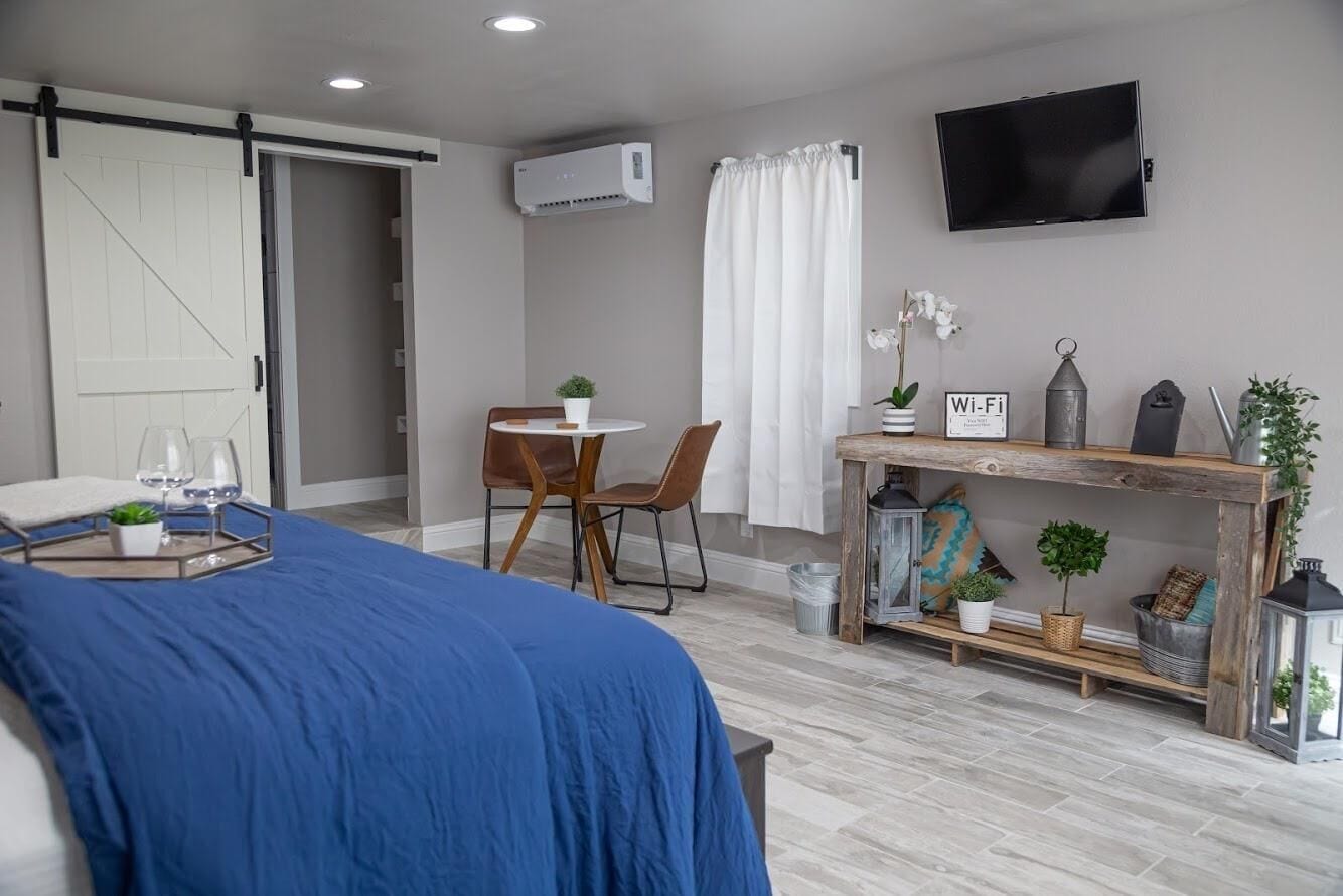 Une chambre à coucher moderne avec un lit, un bureau et un téléviseur.