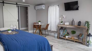 Une chambre à coucher moderne avec un lit, un bureau et un téléviseur.