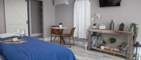 Un dormitorio moderno con cama, escritorio y televisión.