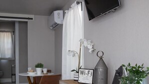 Een moderne keuken met een eetgedeelte, een tv aan de muur en een Wi-Fi signaal.
