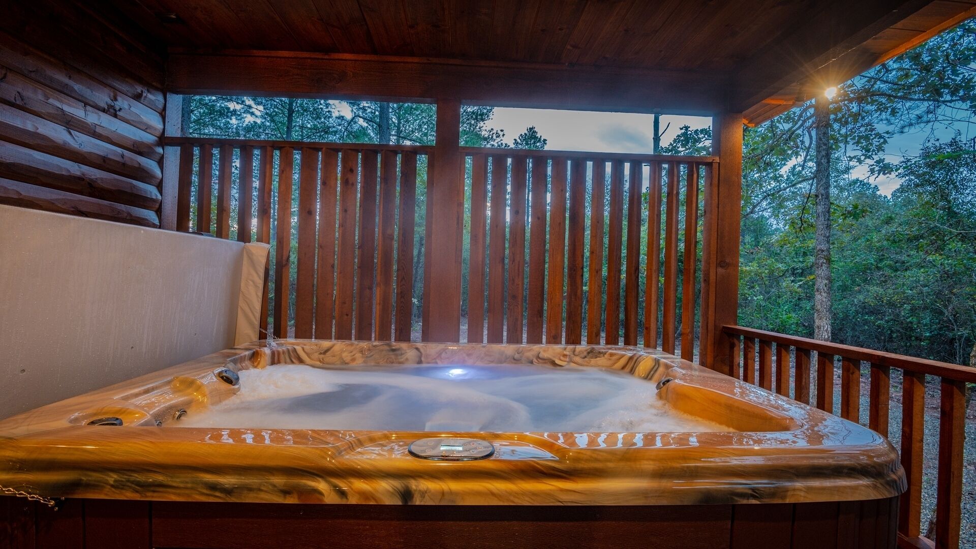 Un bain à remous dans un chalet en bois avec vue sur les arbres.