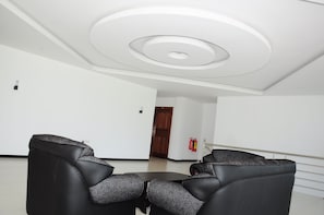 Une pièce moderne avec un plafond de forme circulaire, une table ronde et des chaises en cuir noir.