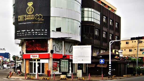A hotel with a distinctive curved facade and a large sign advertising a 50-year anniversary. - Spanhoek Boutique Hotel (Paramaribo)