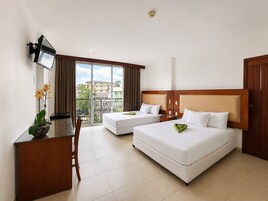 A hotel room with two beds, a desk, a TV, and a balcony with a view.