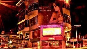 A hotel with a curved facade, a prominent sign, and a large billboard. - Spanhoek Boutique Hotel (Paramaribo)