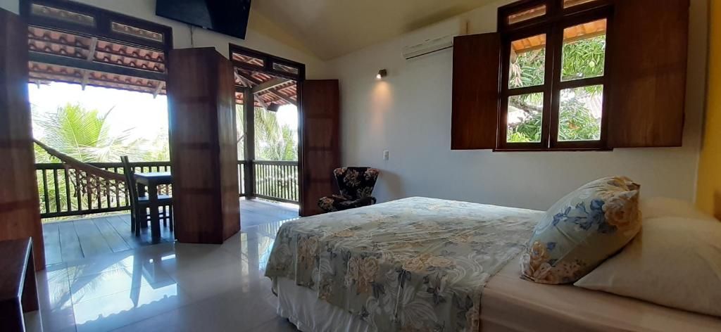 A bedroom with a bed, a chair, a window, and a view of the outdoors.