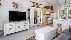 A spacious living room with a flat-screen TV, white cabinetry, and a cozy seating area. - Magdalena Cottage on 1/2 acre (Flagstaff)