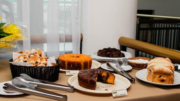 Tarjolla oli erilaisia leivonnaisia sisältävä buffetpöytä, ja siellä oli muun muassa kakku, jonka kyljessä oli teksti ”Bolo Milho”, sekä toinen kakku, jonka kyljessä oli teksti ”Bolo Cenoura”.