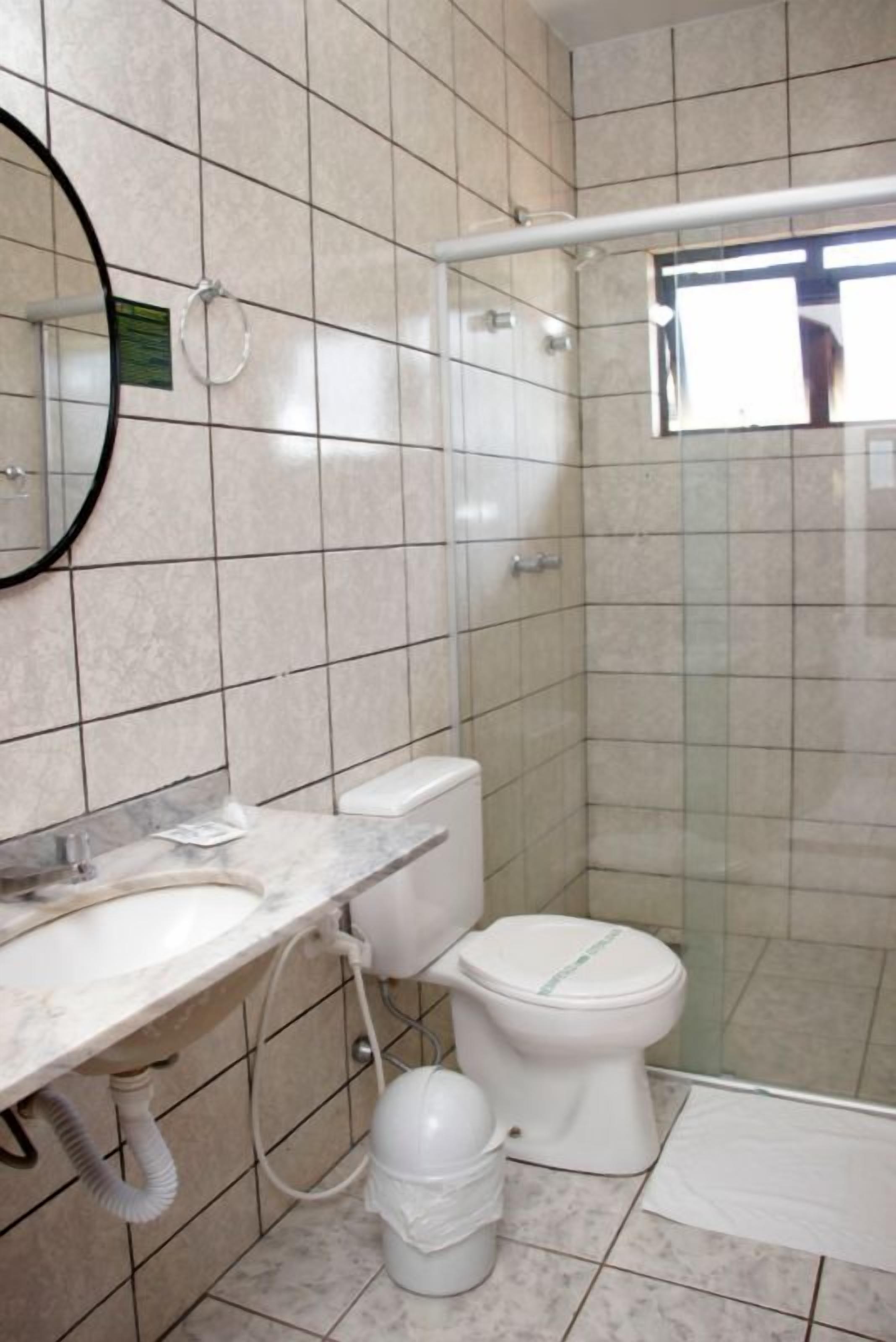 Un baño con inodoro, lavamanos y ducha.