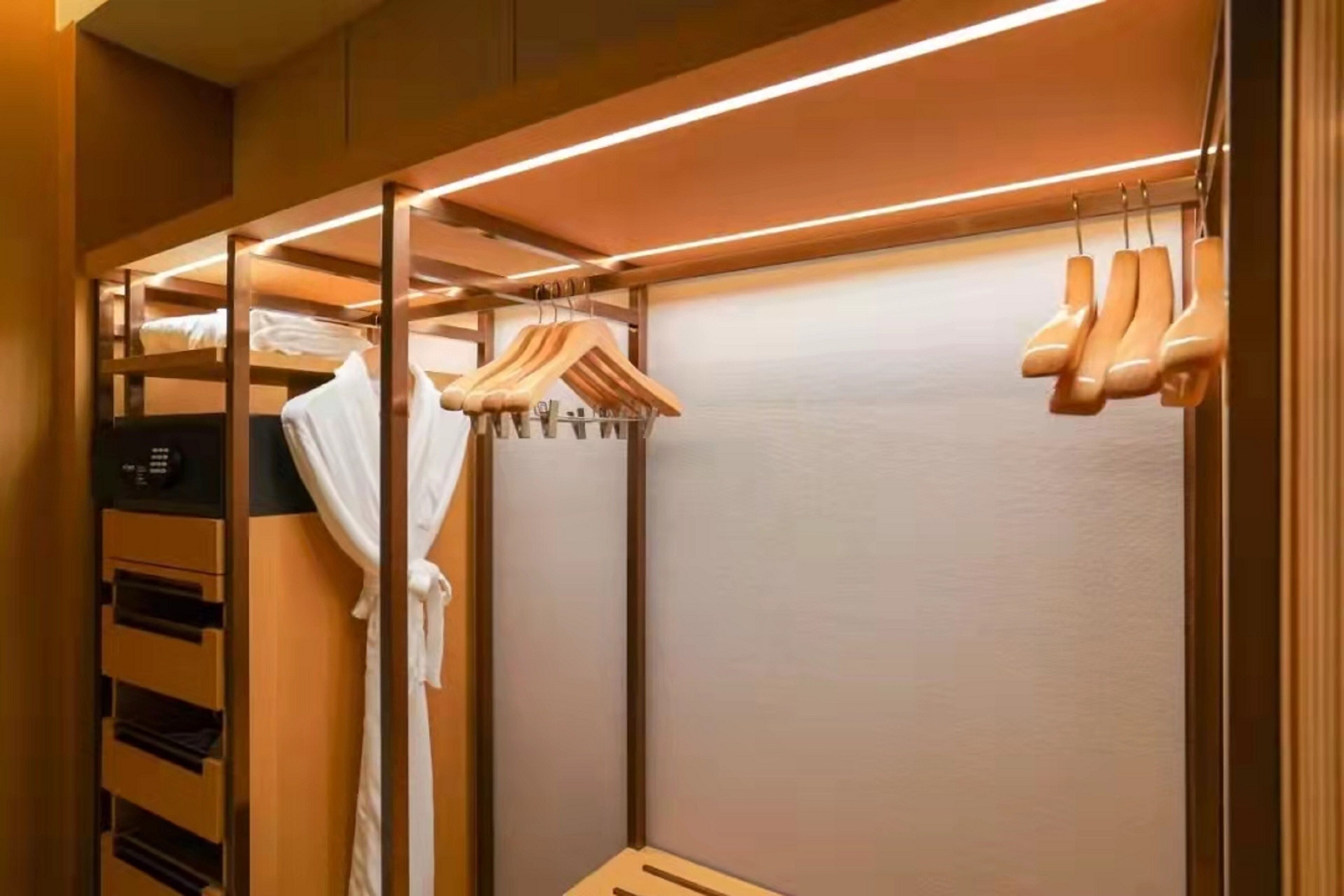 Un armadio moderno con ripiani in legno, un'asta appendiabiti e una scarpiera integrata.