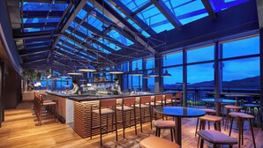 A modern bar area with a high ceiling, large windows, and wooden flooring. - Hyatt Regency Hengqin (Zhuhai)