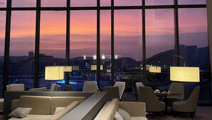 A hotel lobby with large windows, seating area, and modern lamps. - Hyatt Regency Hengqin (Zhuhai)