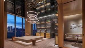 A modern hotel lobby with a large seating area, a staircase, and a view of the cityscape. - Hyatt Regency Hengqin (Zhuhai)