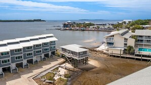 A coastal hotel with multiple buildings, a beach, and a dock.