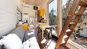 Une petite cabine comprenant un coin cuisine, un espace repas et un canapé.