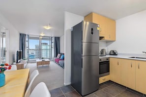 Una cocina moderna con refrigerador de acero inoxidable, gabinetes de madera y horno empotrado.