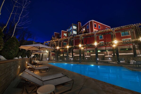 Relax by the pool surrounded by lounge chairs and umbrellas.
