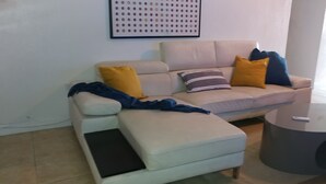 Un salon avec un canapé, une table basse et un cadre photo fixé au mur.